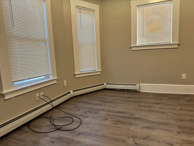 a view of a room with wooden floor and a window