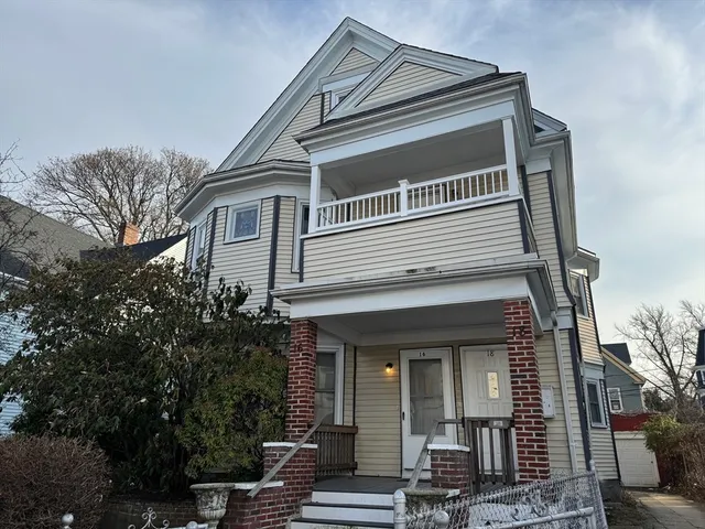 a view of a house with a large windows and flower plants