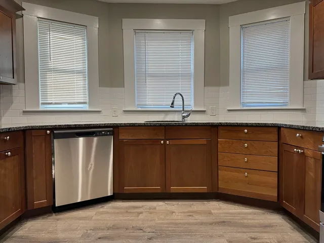 a kitchen with stainless steel appliances granite countertop a sink and a window