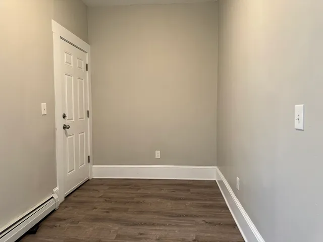 a view of an empty room with wooden floor