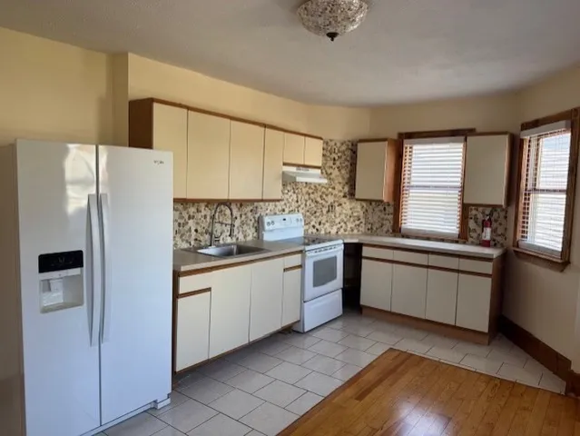 a kitchen with granite countertop a refrigerator and a sink