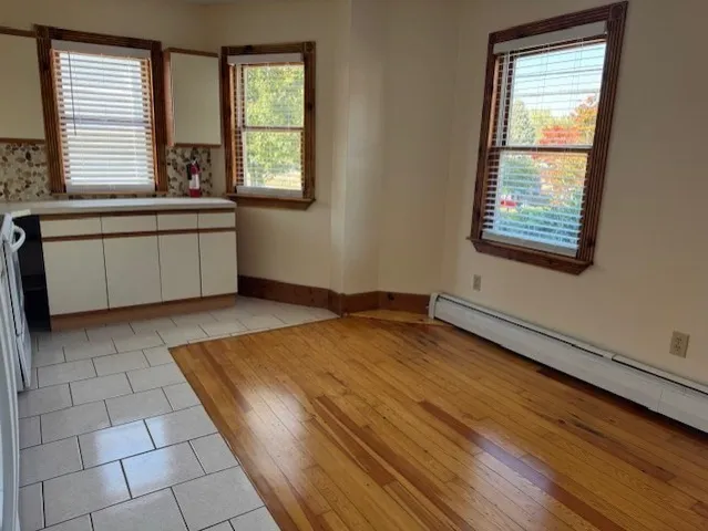 a view of a kitchen with a sink and dishwasher with wooden floor