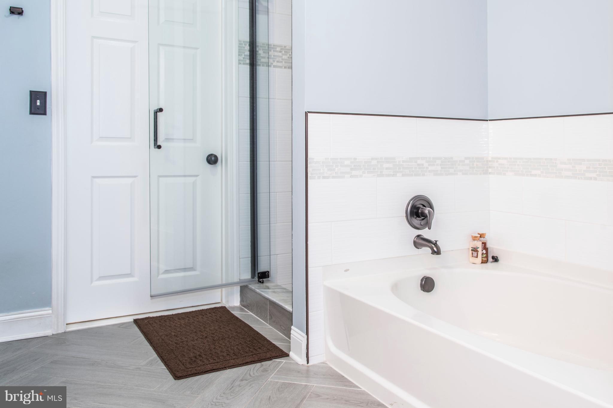 504 Sunset View Terrace Southeast, Unit 206 Leesburg, VA 20175 - Photo 13 of 18 a bathroom with a bathtub and a shower