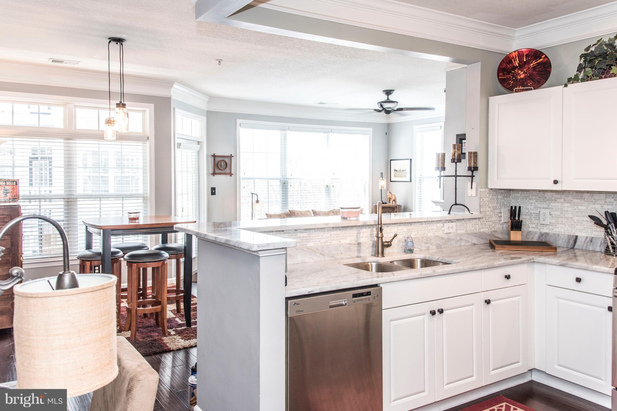 504 Sunset View Terrace Southeast, Unit 206 Leesburg, VA 20175 - Photo 3 of 18 a kitchen with granite countertop a sink stove and cabinets
