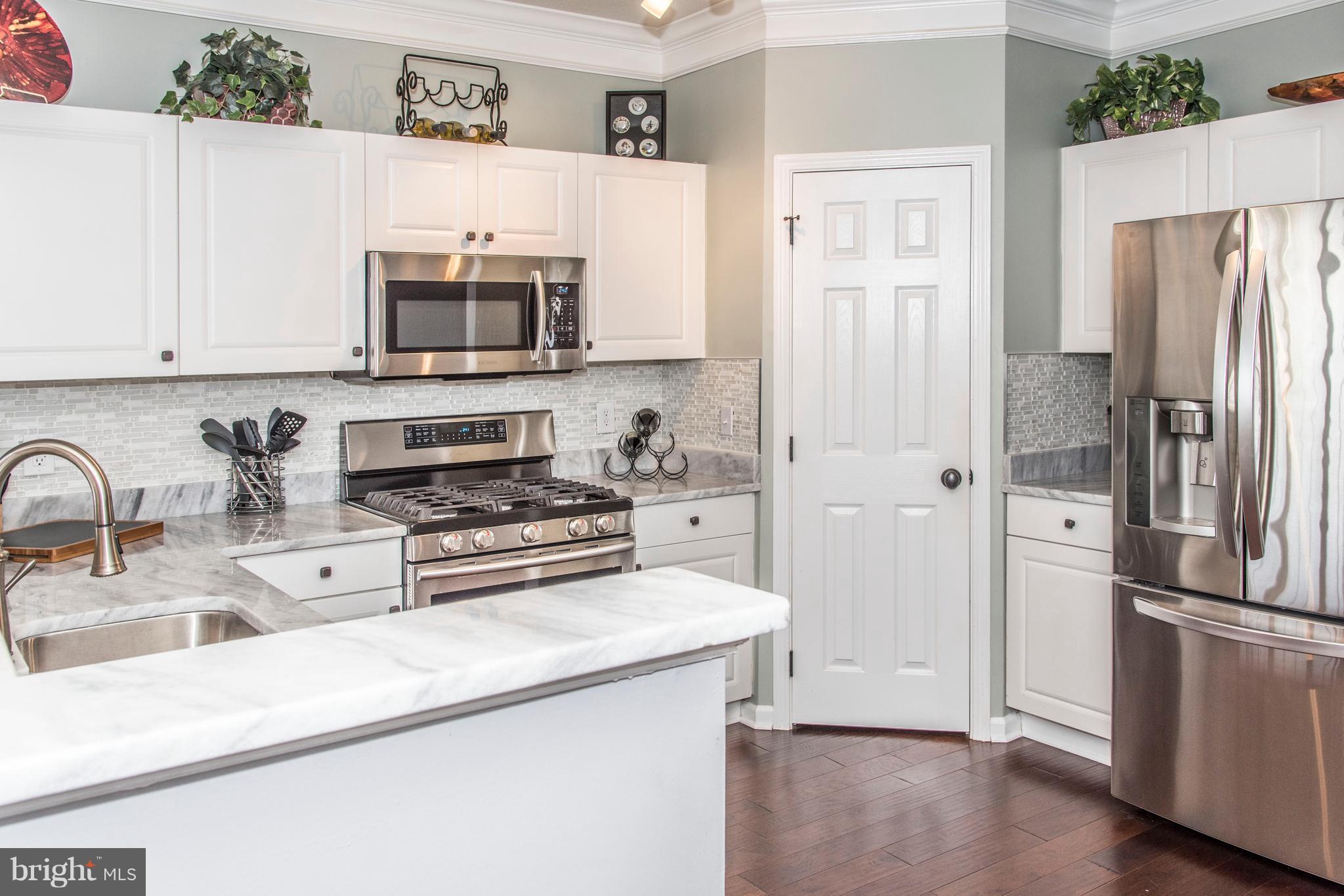 504 Sunset View Terrace Southeast, Unit 206 Leesburg, VA 20175 - Photo 4 of 18 a kitchen with stainless steel appliances a refrigerator stove and sink