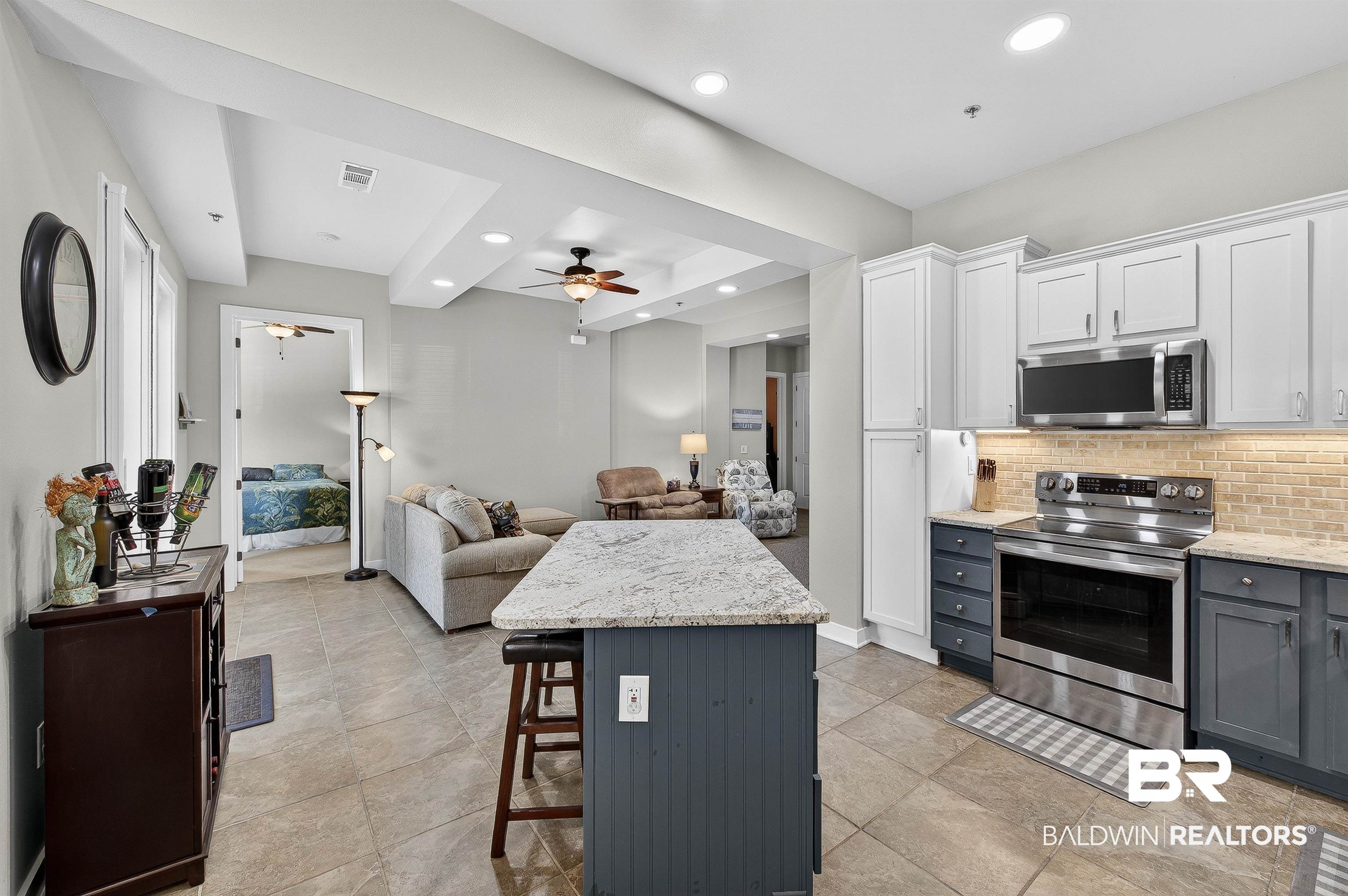 1430 West Regency Road, Unit I102 Gulf Shores, AL 36542 - Photo 31 of 31 Kitchen featuring two tone cabinets, open floor plan, light stone counters, stainless steel appliances, and recessed lighting