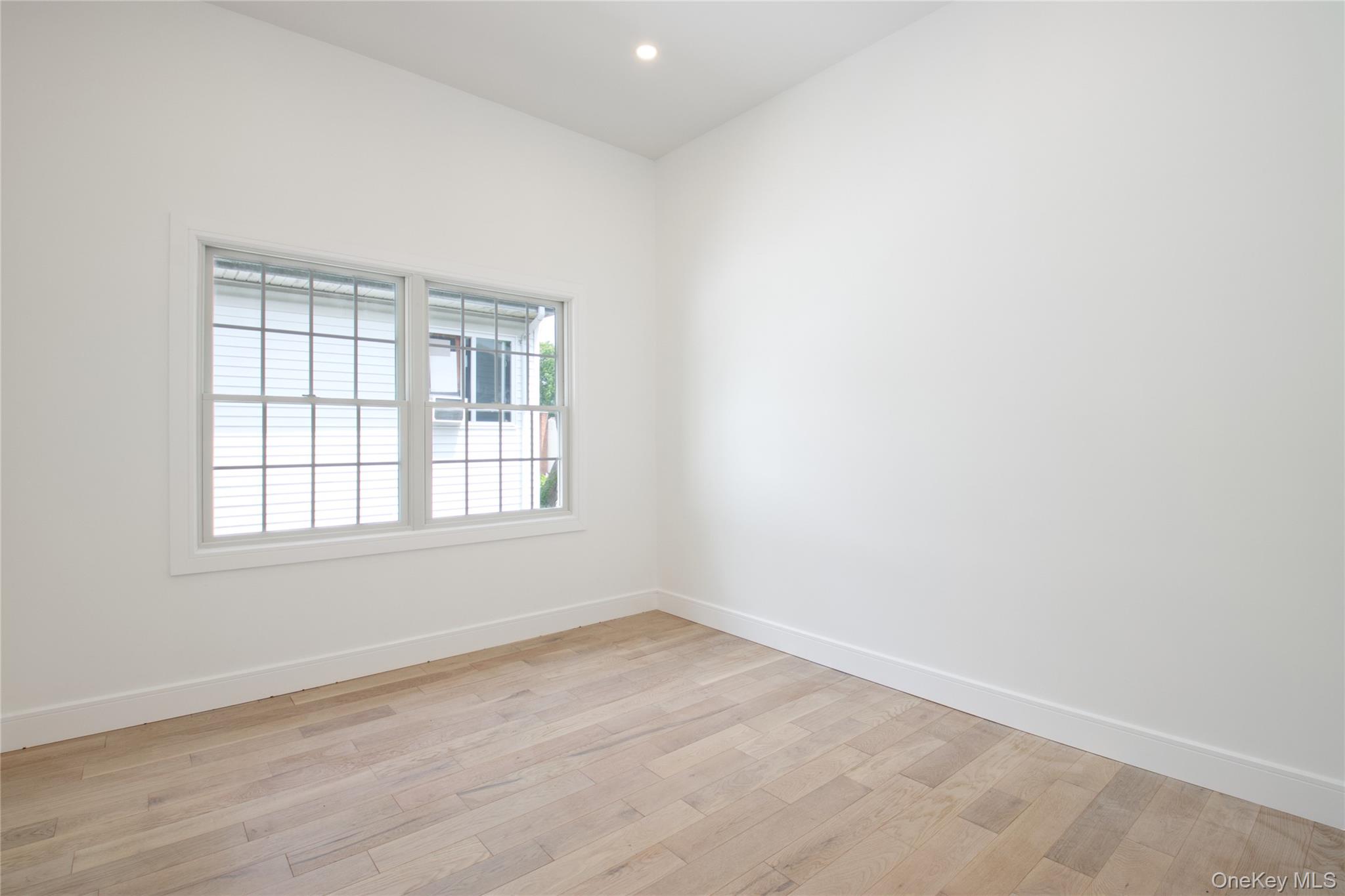 30 Kirkwood Road, Unit B Port Washington, NY 11050 - Photo 27 of 36 an empty room with wooden floor and windows