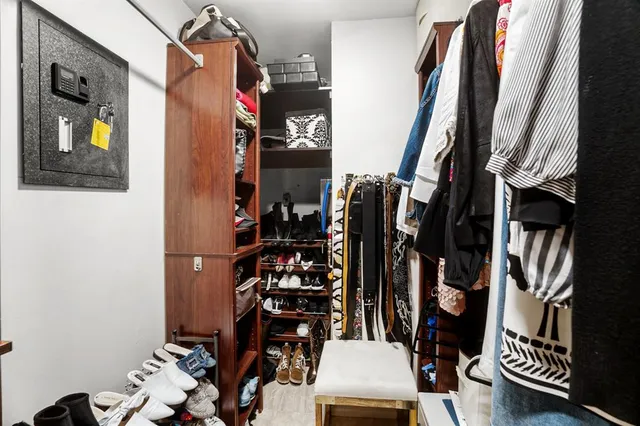 a view of walk in closet with clothes and shoes