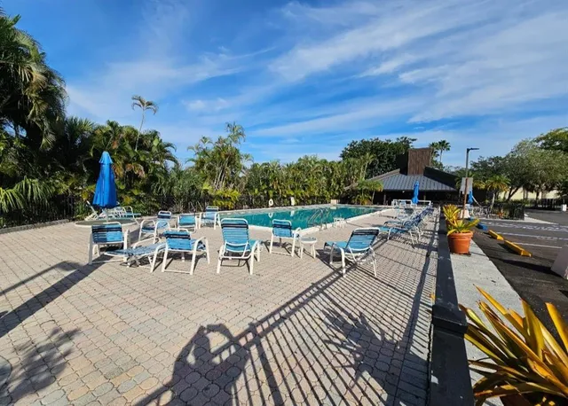a view of a patio with table and chairs and potted plants with wooden floor and fence