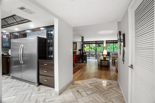 a kitchen with stainless steel appliances kitchen island granite countertop a refrigerator and a sink