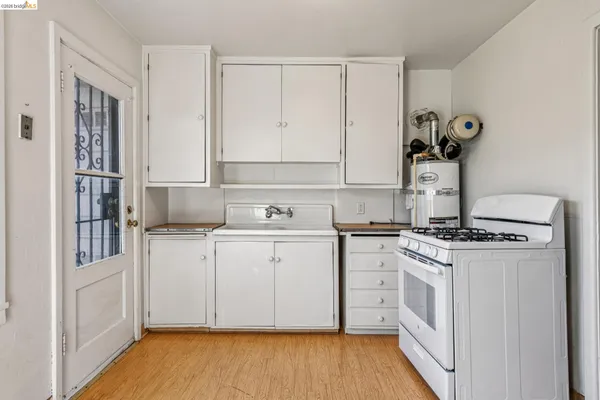 a kitchen with a stove top oven and cabinets