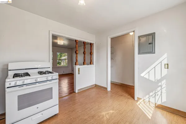 a kitchen with a stove a sink and white cabinets