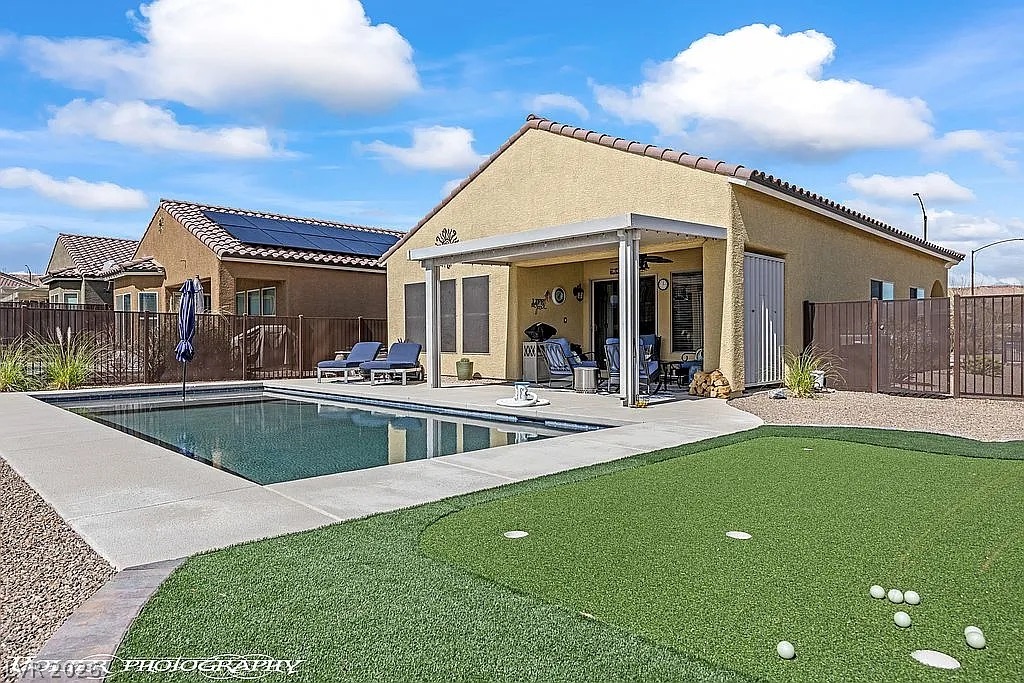 1304 Cottage Ridge Mesquite, NV 89034 - Photo 36 of 52 An inviting pool, putting green, and covered patio create a perfect outdoor entertaining space.