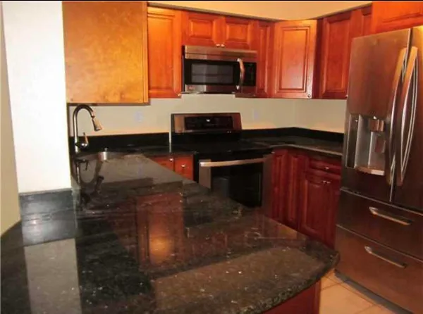 a kitchen with stainless steel appliances granite countertop a sink and a microwave