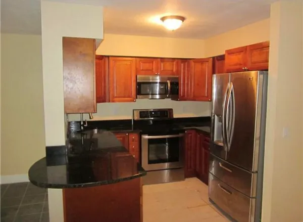 a kitchen with stainless steel appliances granite countertop a refrigerator and a stove