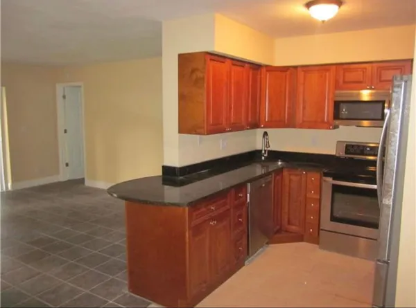 a kitchen with stainless steel appliances granite countertop a sink stove and cabinets
