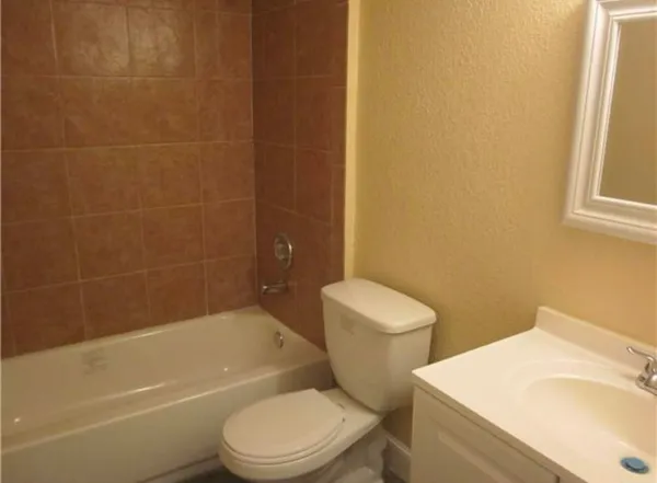 a white toilet and tub sitting next to a bathroom sink