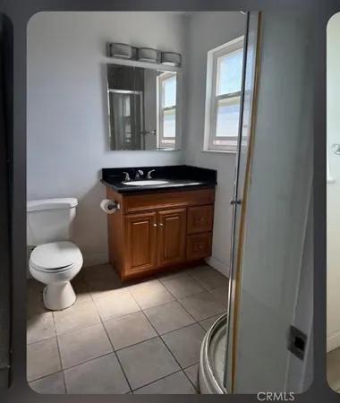 a bathroom with a toilet a sink and mirror