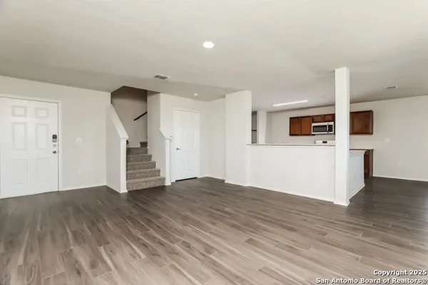 a view of an empty room with wooden floor