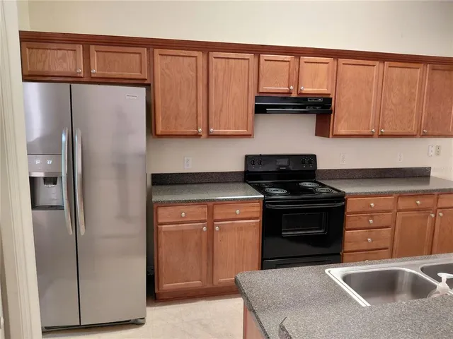 a kitchen with stainless steel appliances granite countertop a refrigerator stove and sink
