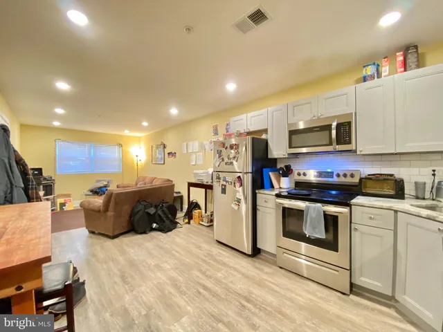 a kitchen with stainless steel appliances kitchen island granite countertop a stove and a refrigerator