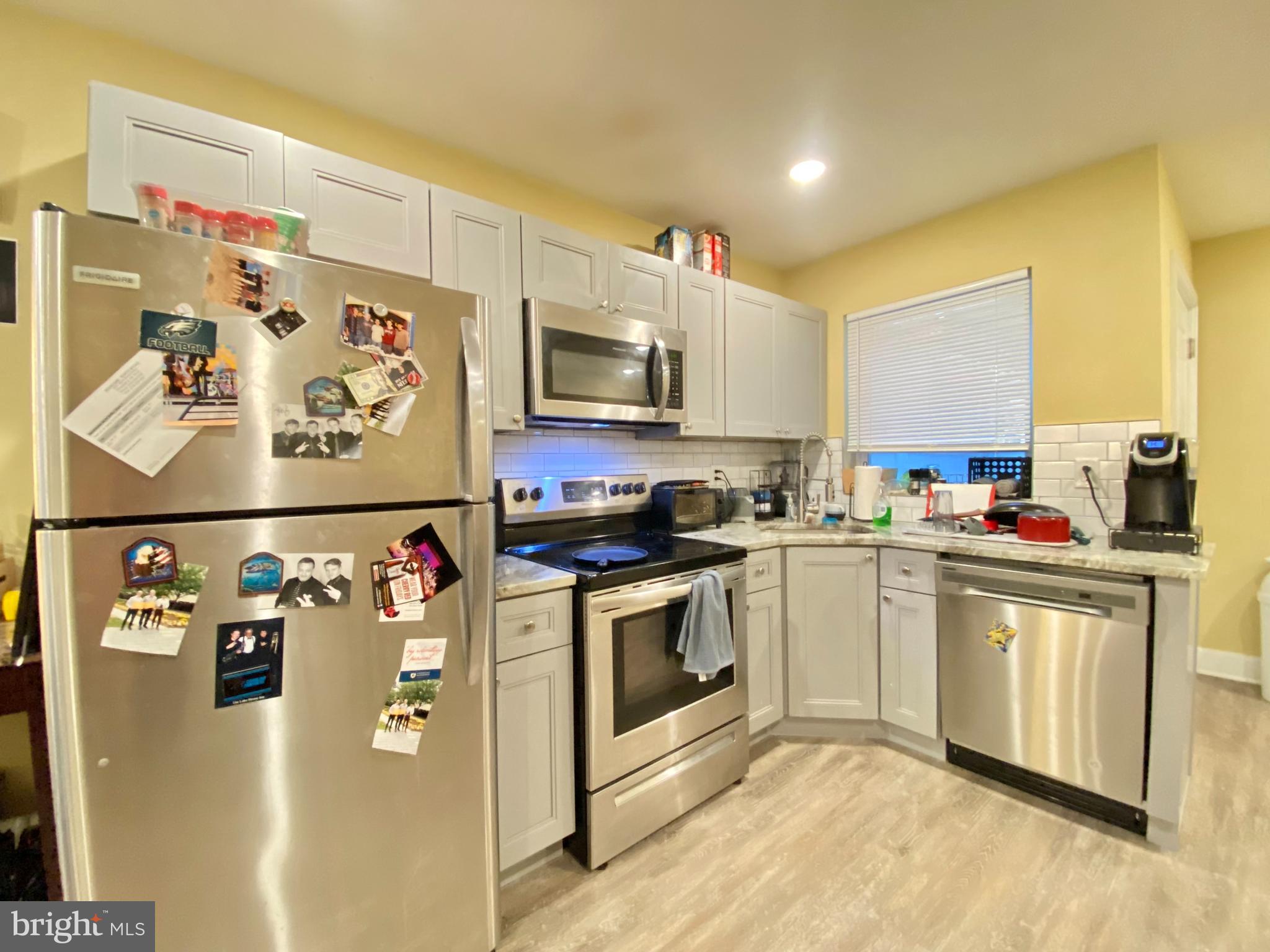 2214 North Camac Street, Unit A Philadelphia, PA 19133 - Photo 4 of 18 a kitchen with stainless steel appliances granite countertop a refrigerator a stove top oven a sink and dishwasher