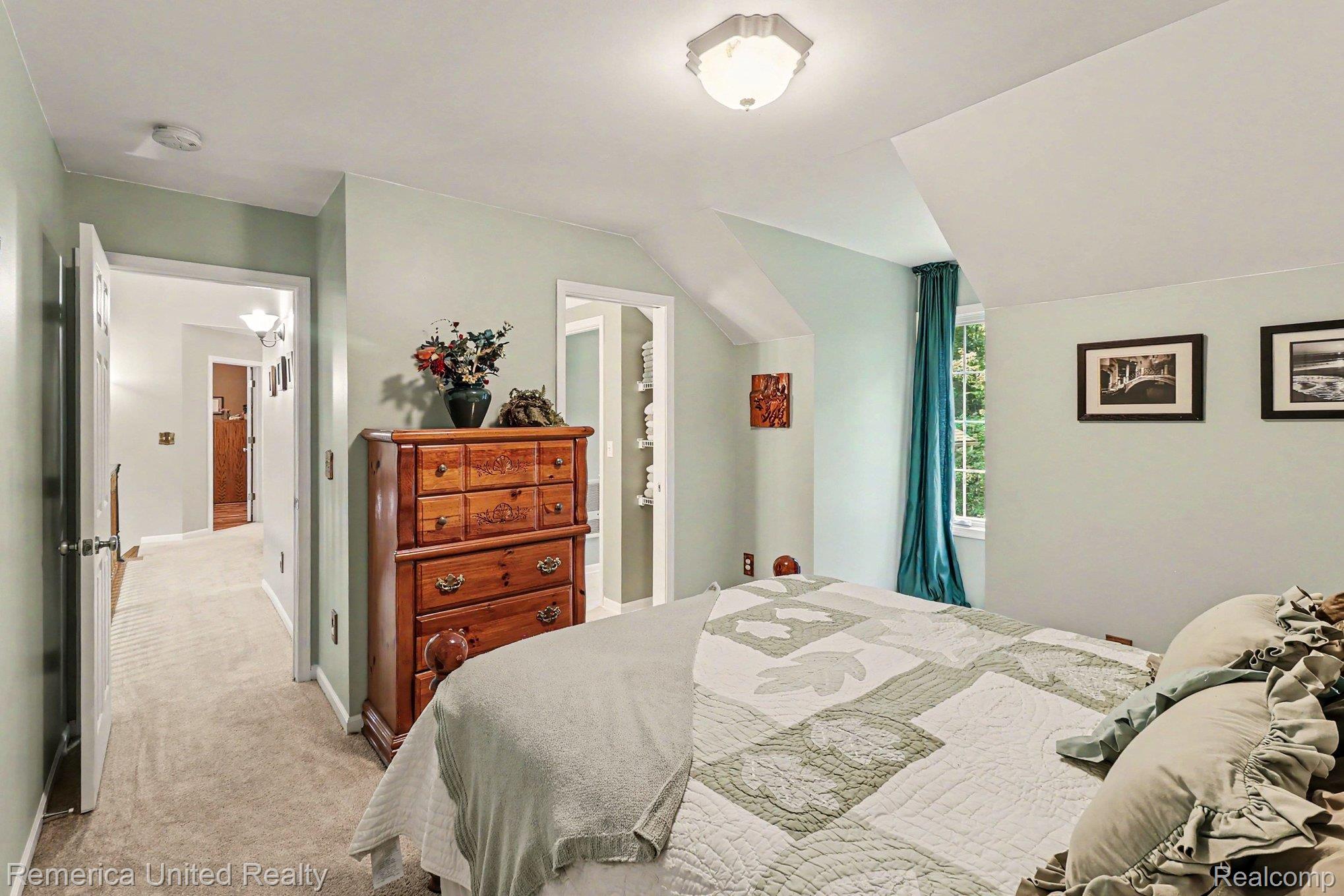 20962 Wasson Road Gregory, MI 48137 - Photo 24 of 39 Carpeted room featuring a sloped ceiling and a window with a forest backdrop