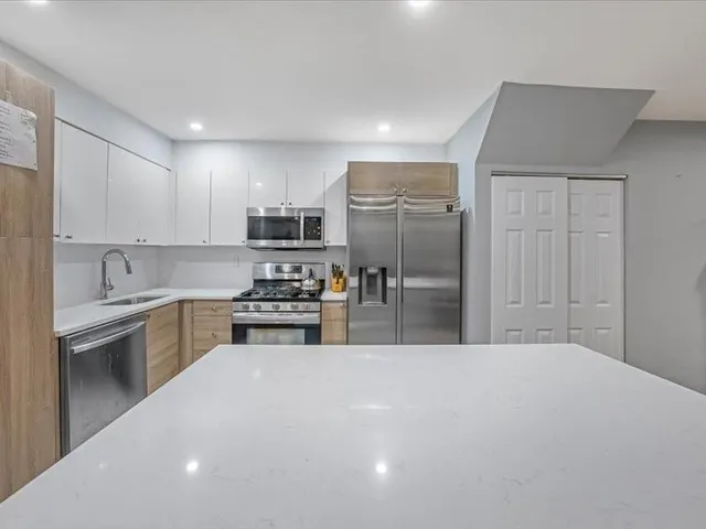 a kitchen with stainless steel appliances a sink stove and refrigerator