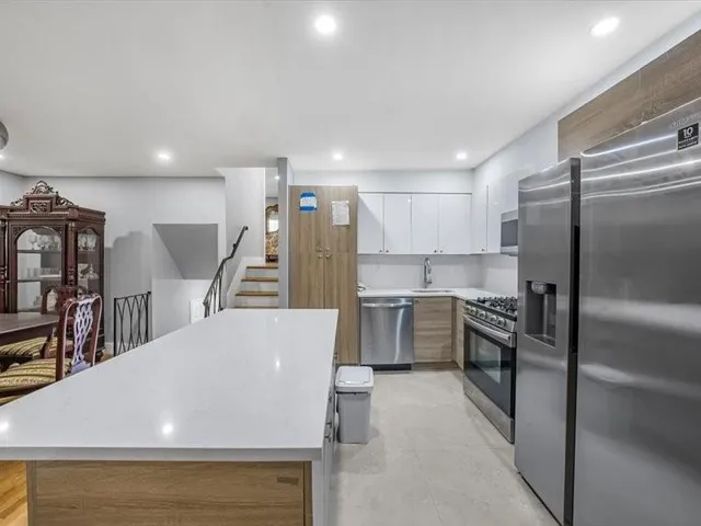 a large kitchen with a large counter top appliances and cabinets