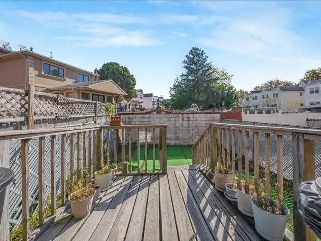 a view of a roof deck with wooden floor and fence