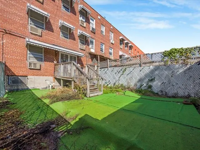 a view of a big building with big yard and large trees