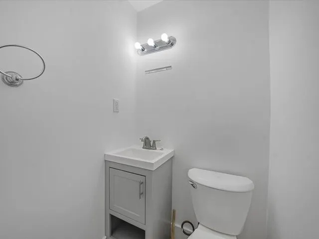 a bathroom with a toilet a sink and mirror