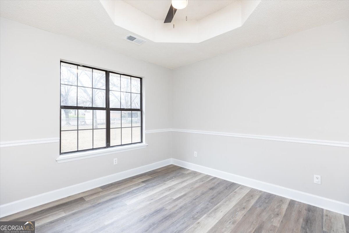 1027 Kathryn Ryals Road Warner Robins, GA 31088 - Photo 13 of 54 an empty room with wooden floor and windows