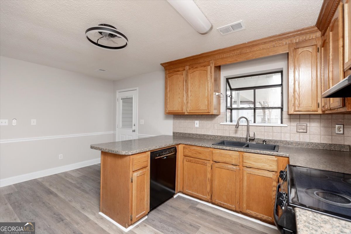 1027 Kathryn Ryals Road Warner Robins, GA 31088 - Photo 16 of 54 a kitchen with a sink cabinets stainless steel appliances and a window