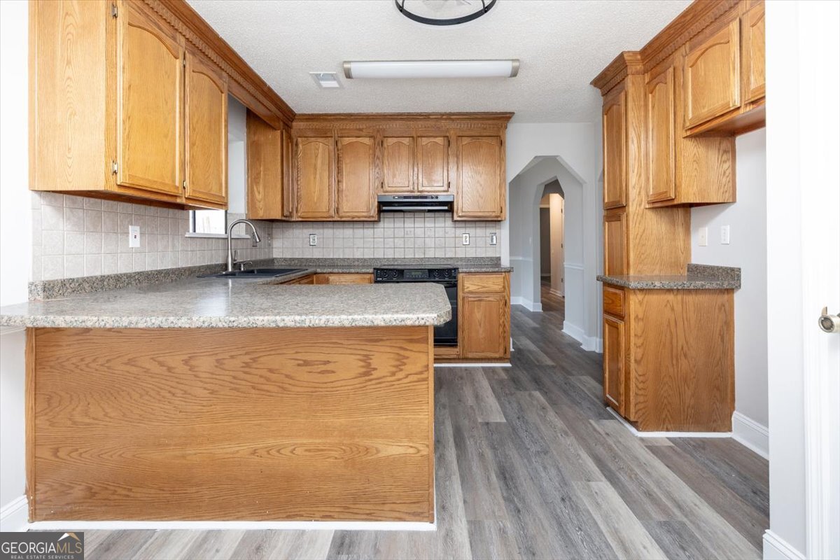 1027 Kathryn Ryals Road Warner Robins, GA 31088 - Photo 20 of 54 a kitchen with granite countertop a sink a stove and cabinets