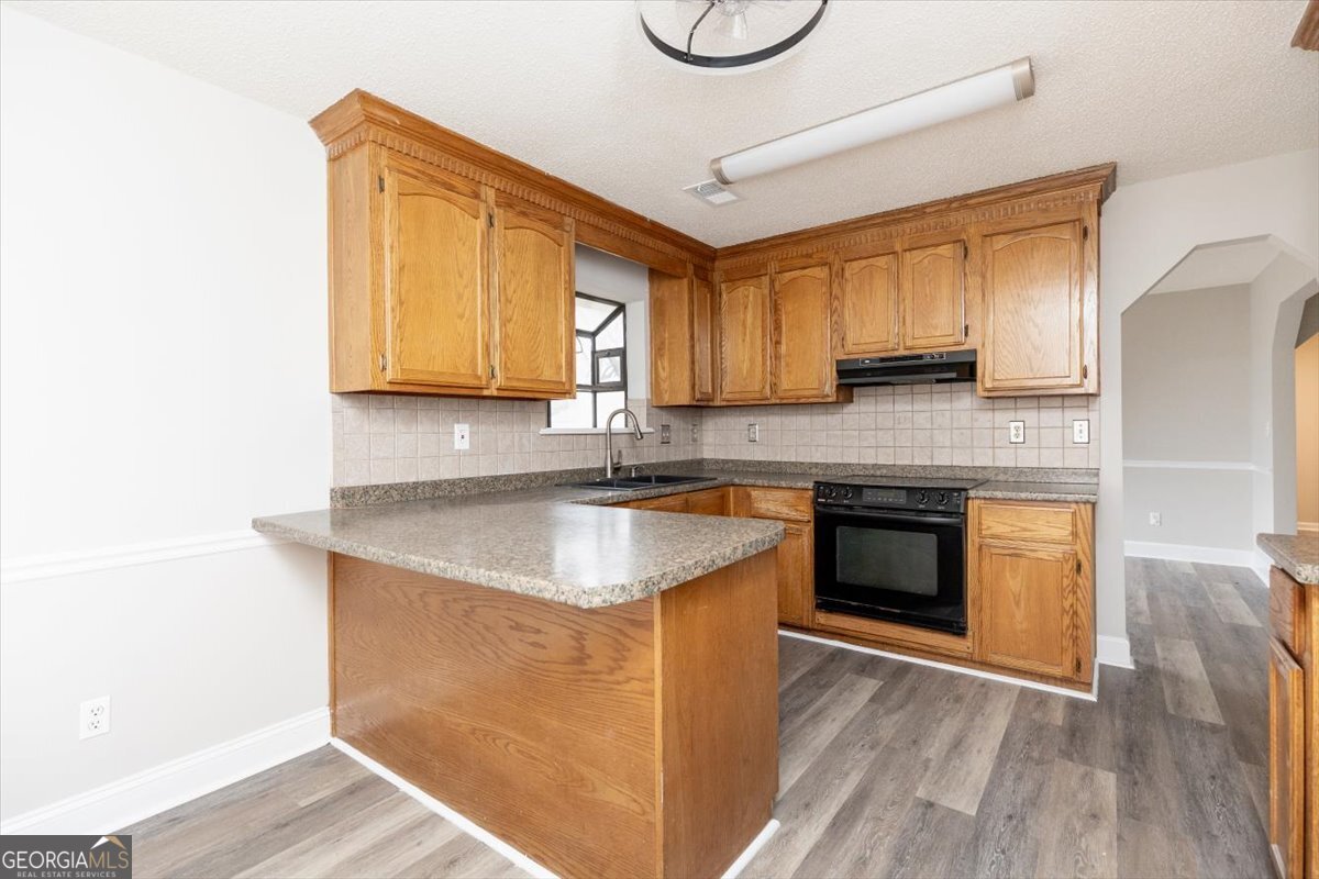 1027 Kathryn Ryals Road Warner Robins, GA 31088 - Photo 21 of 54 a kitchen with granite countertop a sink a stove top oven and cabinetry