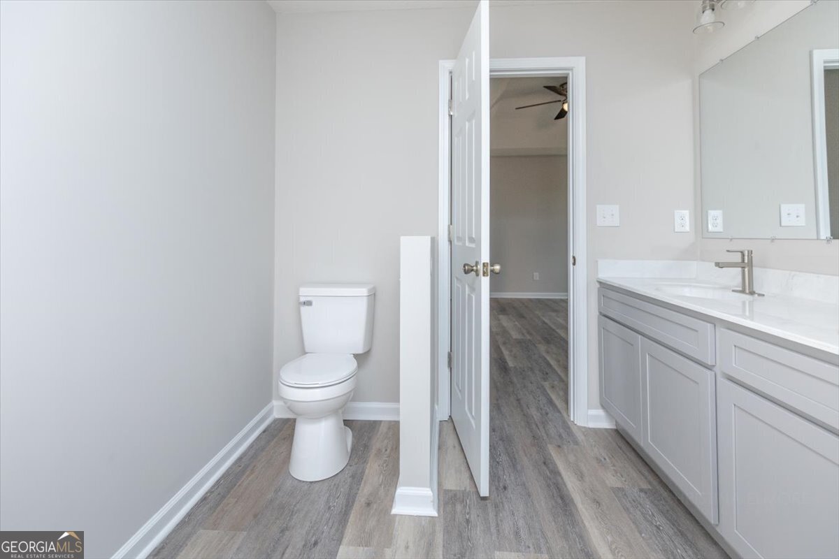 1027 Kathryn Ryals Road Warner Robins, GA 31088 - Photo 35 of 54 a bathroom with a granite countertop toilet a sink and mirror