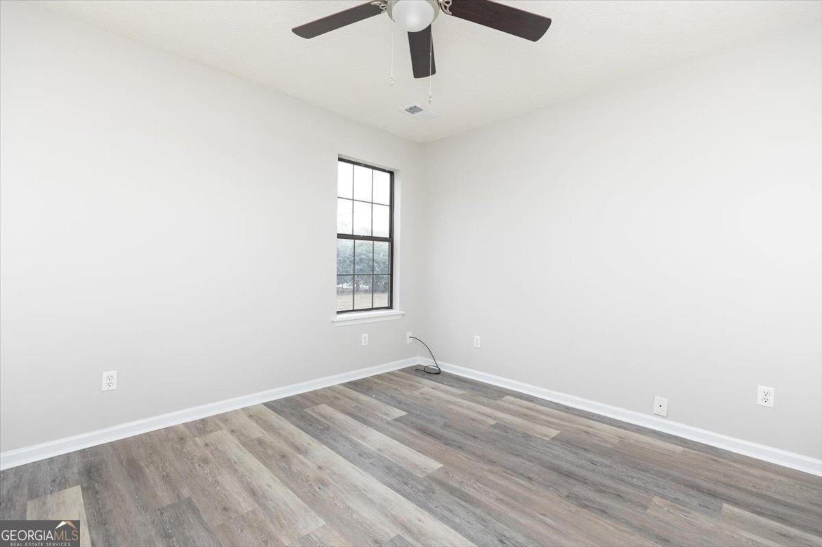1027 Kathryn Ryals Road Warner Robins, GA 31088 - Photo 37 of 54 an empty room with a window and a ceiling fan