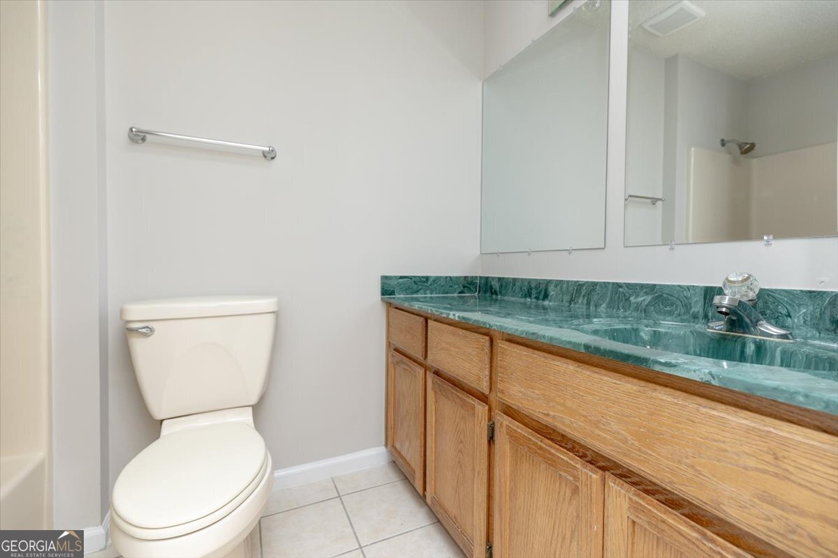1027 Kathryn Ryals Road Warner Robins, GA 31088 - Photo 39 of 54 a bathroom with a granite countertop toilet and a sink