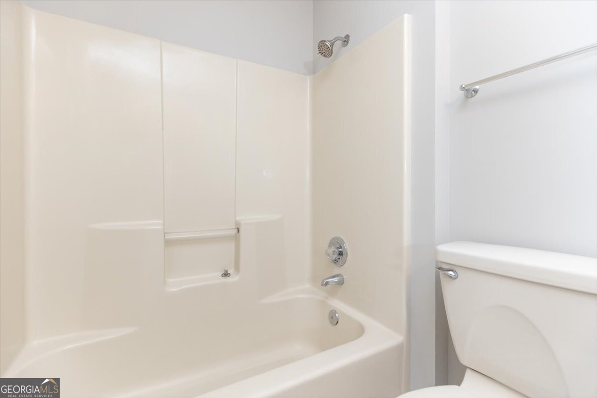 1027 Kathryn Ryals Road Warner Robins, GA 31088 - Photo 40 of 54 a white bath tub sitting next to a white toilet and a shower