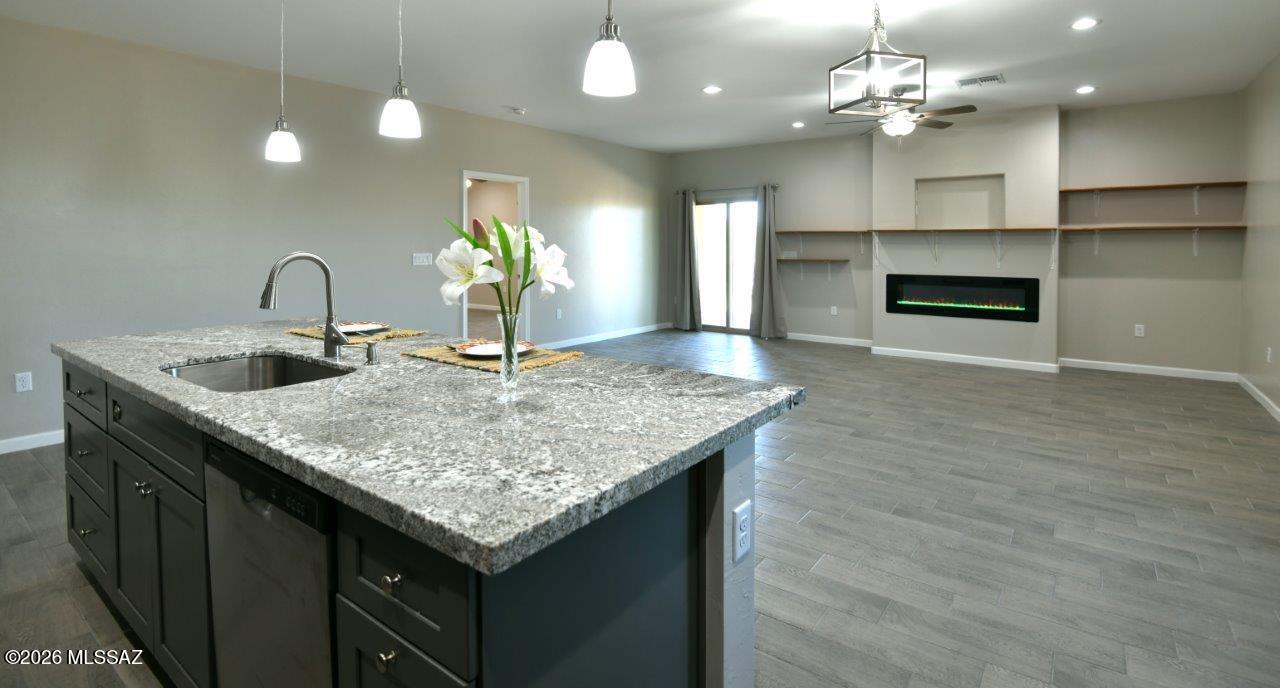 1091 North Vail View Road Vail, AZ 85641 - Photo 8 of 43 a kitchen with kitchen island granite countertop a sink and chandelier