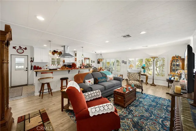 a living room with furniture kitchen view and a large window
