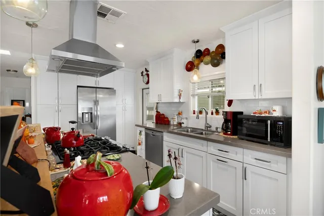 a kitchen with stainless steel appliances granite countertop a sink cabinets and wooden floor