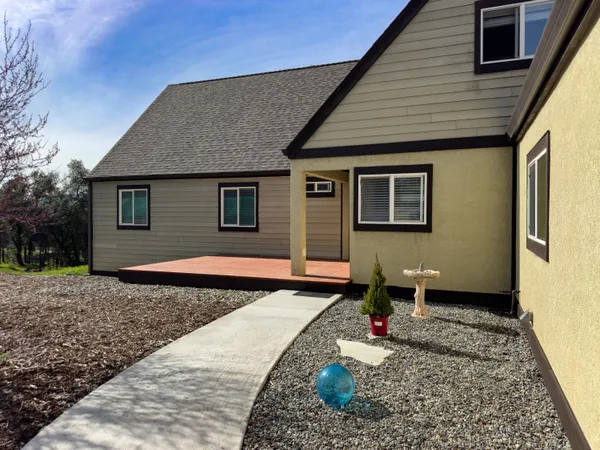 a view of a house with yard and deck
