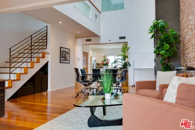 a kitchen with stainless steel appliances granite countertop a refrigerator a sink dishwasher and a oven with wooden floor