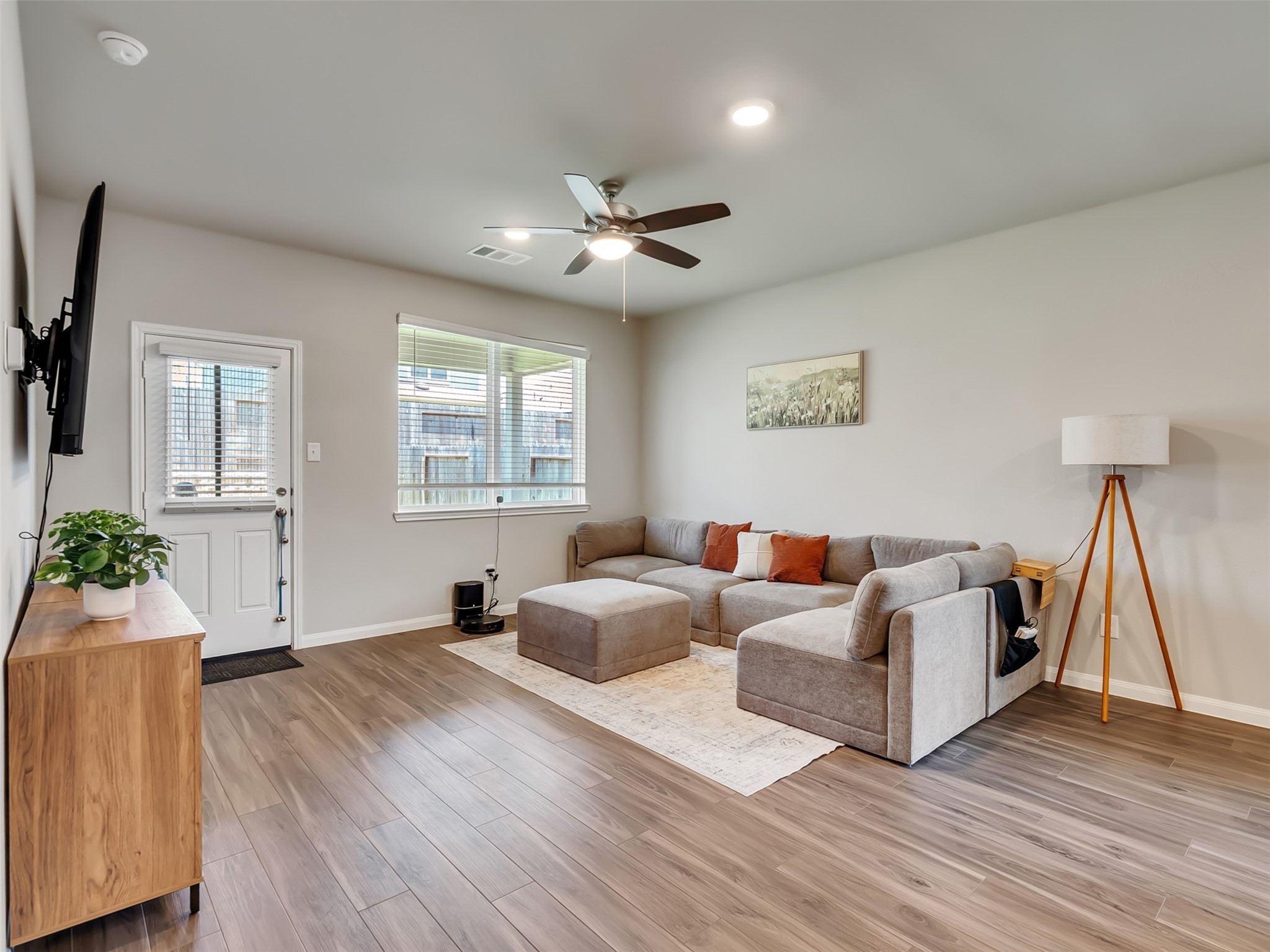 2416 Bluefish Court Conroe, TX 77384 - Photo 29 of 45 a living room with furniture a flat screen tv and a wooden floor