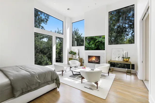 a living room with furniture a fireplace and a floor to ceiling window