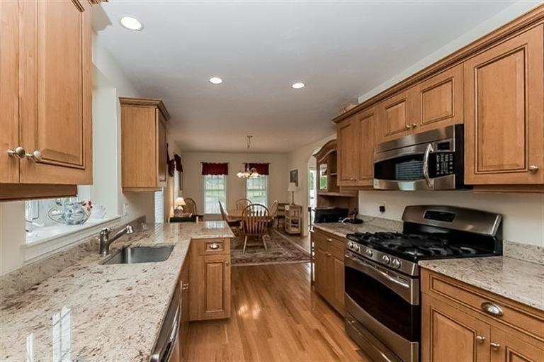 80 Brookside Road, Unit 205 Bourne, MA 02532 - Photo 14 of 35 a large kitchen with stainless steel appliances granite countertop a stove a sink dishwasher a microwave oven with cabinets and wooden floor