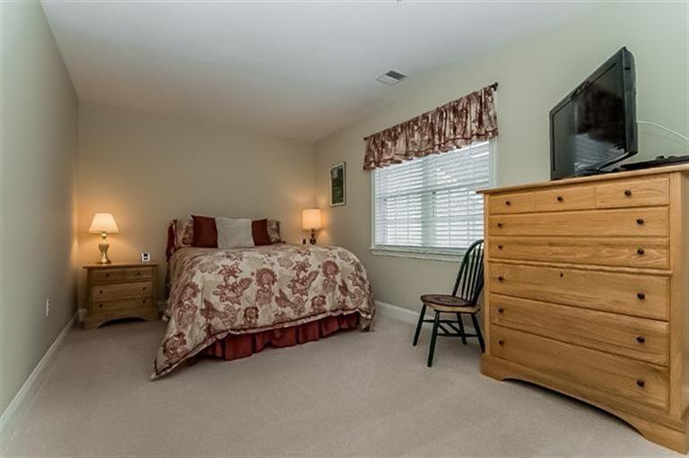 80 Brookside Road, Unit 205 Bourne, MA 02532 - Photo 24 of 35 a bedroom with a bed and flat screen tv