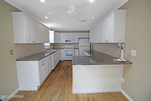 a kitchen with white cabinets and white appliances
